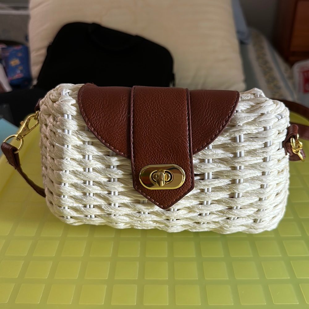 Cream colored straw bag with brown leather look handle
